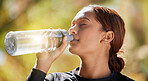 Fitness, nature and woman drinking water after running for hydration, refresh and thirst. Sports, runner and female athlete enjoying a drink after cardio training for a race, marathon or competition.