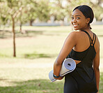 Portrait of black woman in park with yoga mat and from back, smile in nature for health and fitness mindset. Nature, zen and yoga, happy face on woman from behind ready for pilates workout on grass.