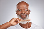 Elderly, black man with comb for beard, beauty and grooming with hygiene and cosmetic care against studio background. Hair care mockup, brush body hair and face portrait with treatment and cosmetics