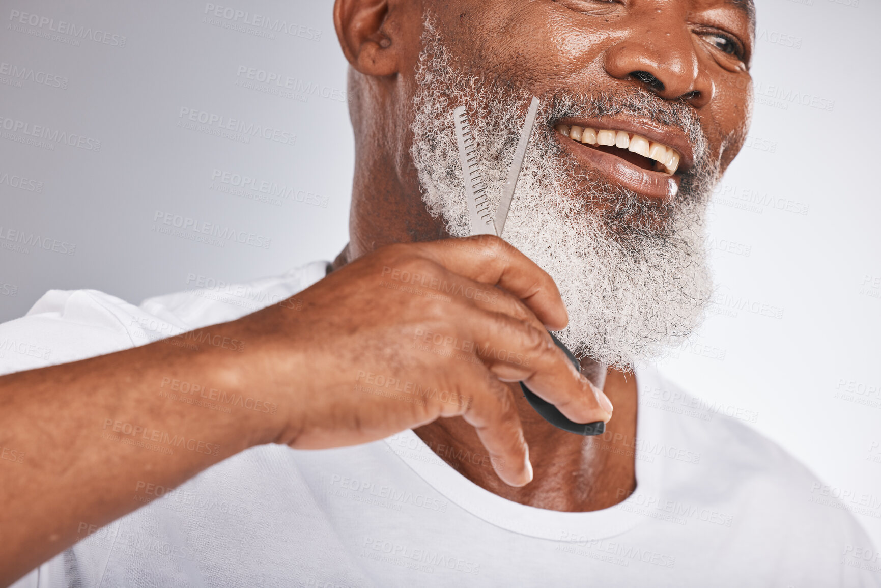 Buy stock photo Beard, beauty and shaving with a senior black man cutting his facial hair in studio on a gray background for grooming. Happy, skin and face with a mature male using scissors to cut for a shave