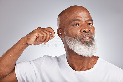 Buy stock photo Cotton swab, earwax cleaning and senior black man portrait for grooming hygiene, self care and cosmetics dirt removal in white studio background. Elderly african model, ears cleaner and body care