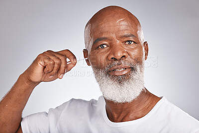 Buy stock photo Senior black man, ears cleaning and cotton bud for wax removal, grooming hygiene and self care cosmetics earwax cleaner in white studio background. Elderly african model, face and body care cleansing