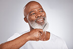Elderly, black man with comb for beard, beauty and grooming with hygiene and cosmetic care against studio background. Hair care mockup, brush body hair and face with hair treatment and cosmetics
