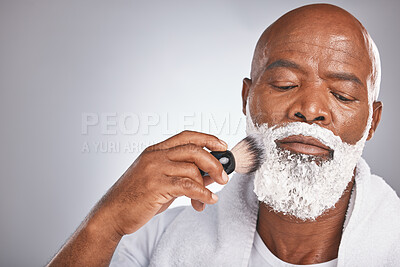 Buy stock photo Face, shaving cream and black man with brush on beard, skincare spa treatment on grey background. Health, mock up and facial hair, mature man morning shave routine with space for product placement. 
