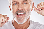 Dental, floss and face of senior man in studio isolated on a gray background. Portrait, cleaning or elderly male model with product flossing teeth for oral wellness, healthy gum hygiene or tooth care