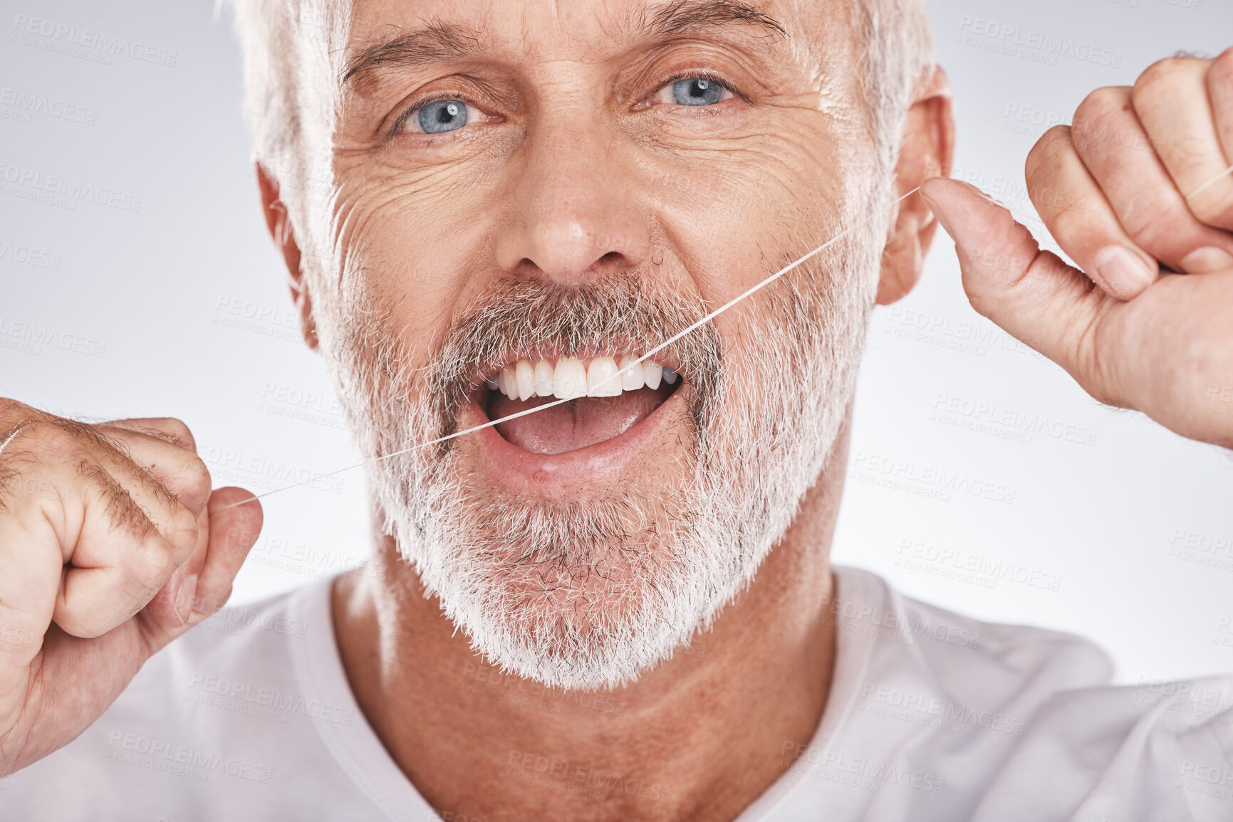 Buy stock photo Dental, floss and face of senior man in studio isolated on a gray background. Portrait, cleaning or elderly male model with product flossing teeth for oral wellness, healthy gum hygiene or tooth care