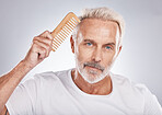Mature man, portrait and hair comb on studio background from barbershop, salon skincare and healthy cosmetics. Face, male model and brushing hair care for fashion, shampoo product and morning routine