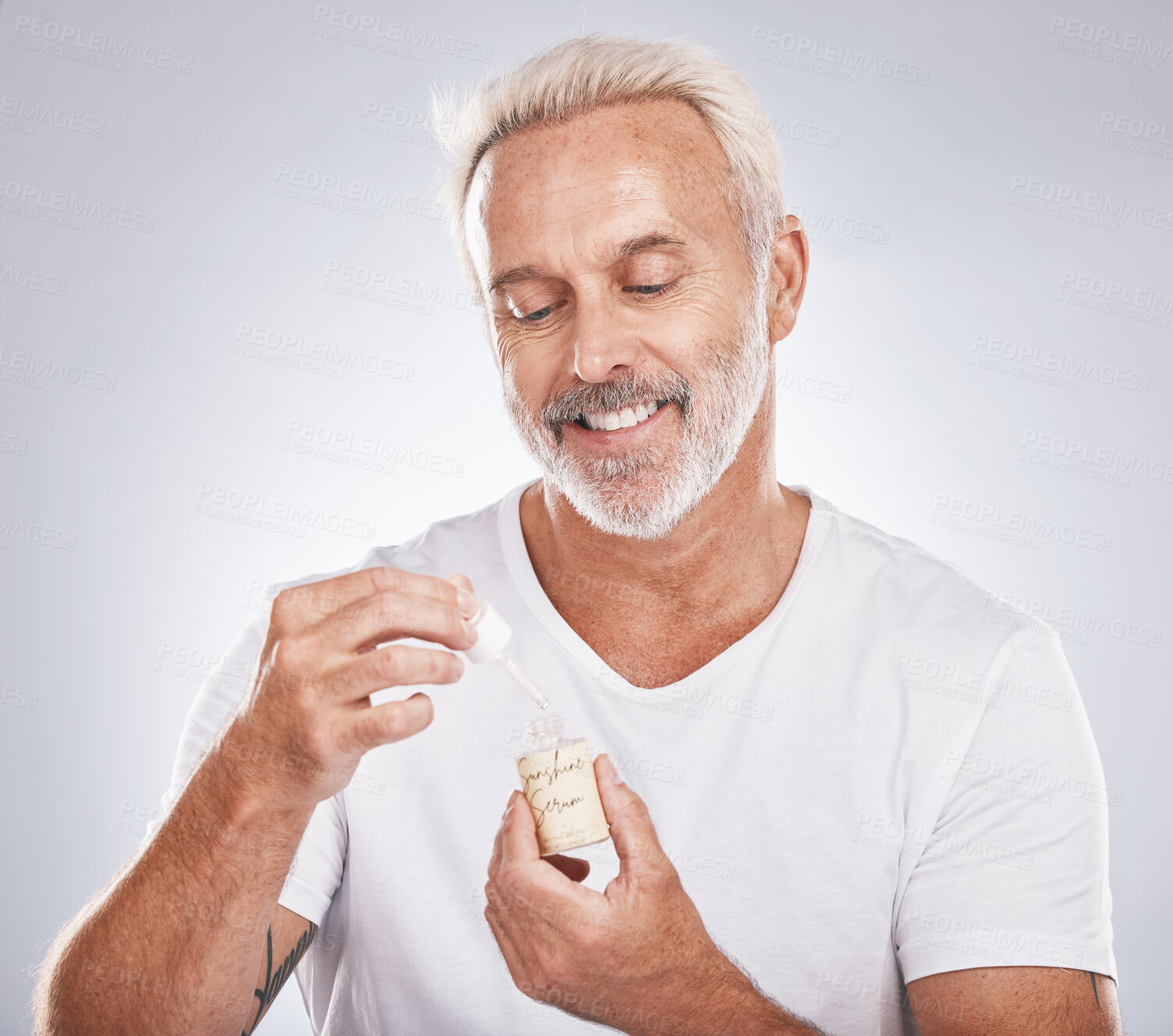 Buy stock photo Skincare, health and senior man with face serum in a studio for a wellness, cosmetic and natural face routine. Cosmetics, beauty and elderly guy with facial oil for skin treatment by gray background.