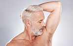 Grooming, hygiene and man with fresh armpits, smelling clean and wellness after shower on a studio background. Healthcare, skincare and cosmetics senior model with underarm smell after cleaning body