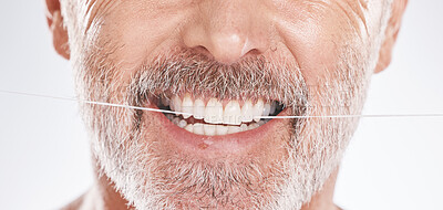 Buy stock photo Dental, floss and mouth of senior man in studio isolated on a gray background. Hygiene, cleaning and elderly male model with product flossing teeth for oral wellness, tooth care and healthy gums.