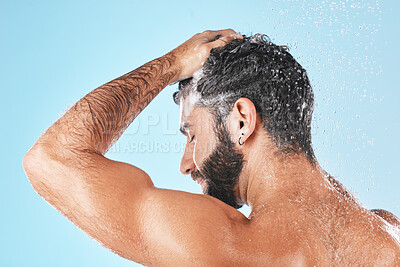 Buy stock photo Face, shampoo shower and water splash of man in studio isolated on a blue background. Water drops, hair care and back of male model washing, cleaning or bathing for healthy skin, skincare and hygiene