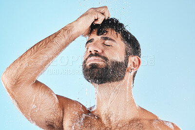 Buy stock photo Water, shower and a man washing hair with shampoo in studio on a blue background for beauty or hygiene. Hair, cleaning and bathroom with a handsome male wet in the bathroom while bathing for haircare