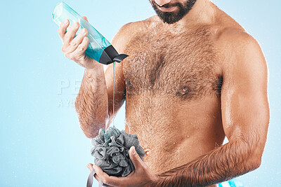 Buy stock photo Shower gel, body care and man in a studio for skin hygiene, health and wellness after a shower. Soap, morning routine and male model cleaning or washing his wet body with a sponge by blue background.