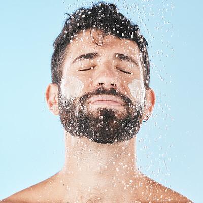 Buy stock photo Water, man with face and cream for cleaning in shower with hygiene, grooming and skincare against blue studio background. Clean, model with water drops and facial, natural treatment and cosmetic care