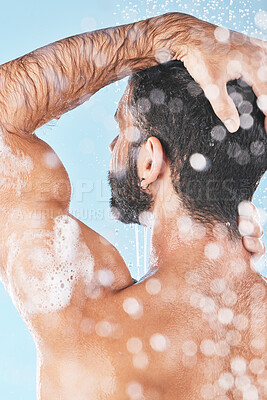 Buy stock photo Shower, water and man cleaning hair with shampoo, conditioner and hair products on blue background. Hygiene, grooming and back of male washing body in bathroom for self care, wellness and skincare