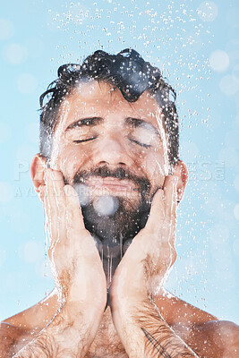 Buy stock photo Wellness, water or man in shower cleaning skin or washing face and body in morning grooming routine in studio. Blue background, hands or healthy male model with self care, self love or a happy smile