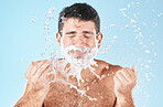 Man, shave and water splash for beauty in studio with wellness, health or self care by blue background. Model, cream and water with hands for healthy facial, self love or cosmetics by studio backdrop