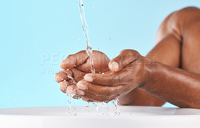 Buy stock photo Water splash, hands and cleaning with beauty and black man, hygiene zoom and hydration with water mockup. Clean water drops, splash and skincare with natural cosmetics against blue studio background