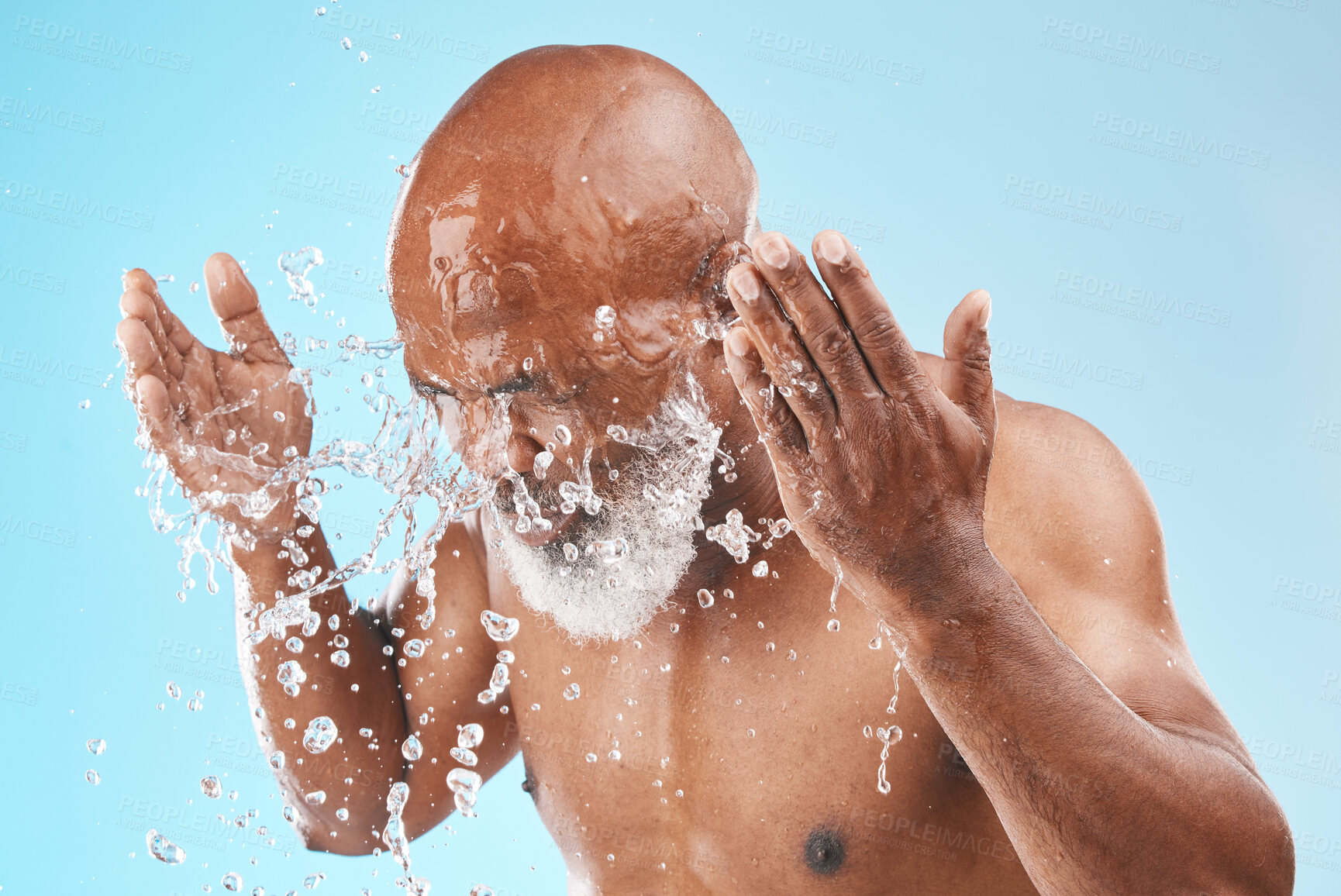 Buy stock photo Black man cleaning face with water splash, healthy skincare on studio blue background for shower, cosmetics and body care transformation. Male model, senior beauty and facial hygiene with clean water