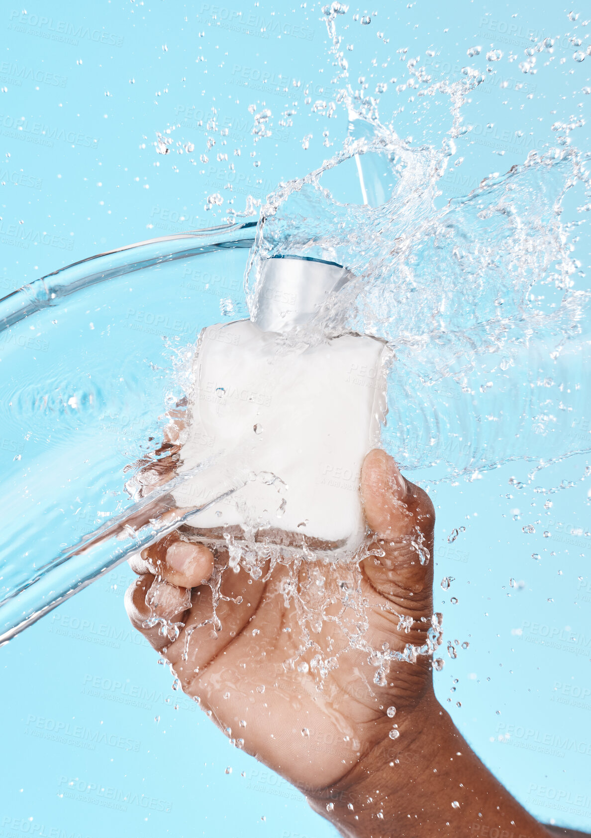 Buy stock photo Water splash, black man and hand with skincare bottle in studio on a blue background. Hygiene, cleaning and male model holding lotion cosmetics or moisturizer product for beauty or skin health.