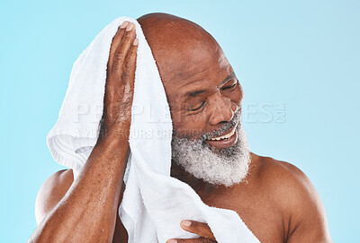 Buy stock photo Shower, senior man and towel for cleaning, cosmetics and hygiene against blue studio background. Black male, mature guy and cloth for skincare, dry and spa body care for beauty, retirement and luxury