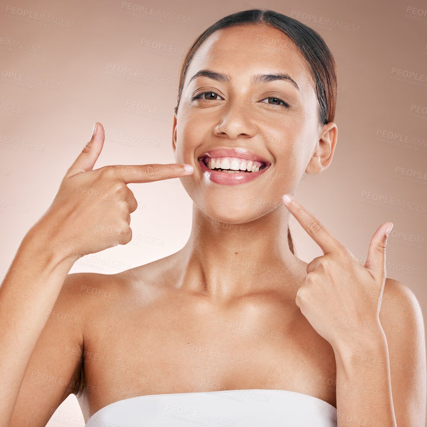 Buy stock photo Smile, face and woman pointing to teeth on studio background for wellness, aesthetic beauty or cosmetics. Portrait of model, dental health and showing clean mouth, fresh breath and happy oral results