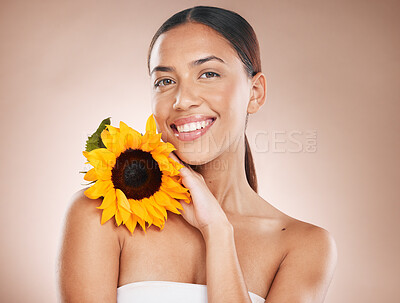 Buy stock photo Beauty, skincare and flower with portrait of woman for natural, cosmetics and organic facial product. Spring, sunflower and smile with face of girl model for self care, luxury and wellness in studio