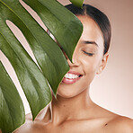 Black woman, smile and leaf with beauty, studio and cosmetic wellness with smile, face glow and makeup. Model, skin health and facial cosmetics, self care and aesthetic with leaves by studio backdrop