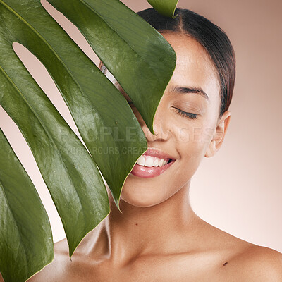 Buy stock photo Black woman, smile and leaf with beauty, studio and cosmetic wellness with smile, face glow and makeup. Model, skin health and facial cosmetics, self care and aesthetic with leaves by studio backdrop