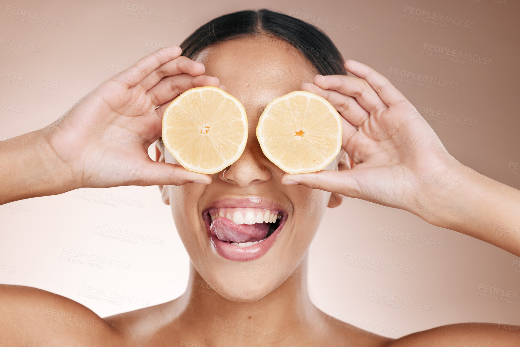 Buy stock photo Woman face, tongue and lemon skincare hands on studio background in organic dermatology routine and healthcare wellness.  Zoom, happy and fun beauty model and facial fruit, diet food and eyes product