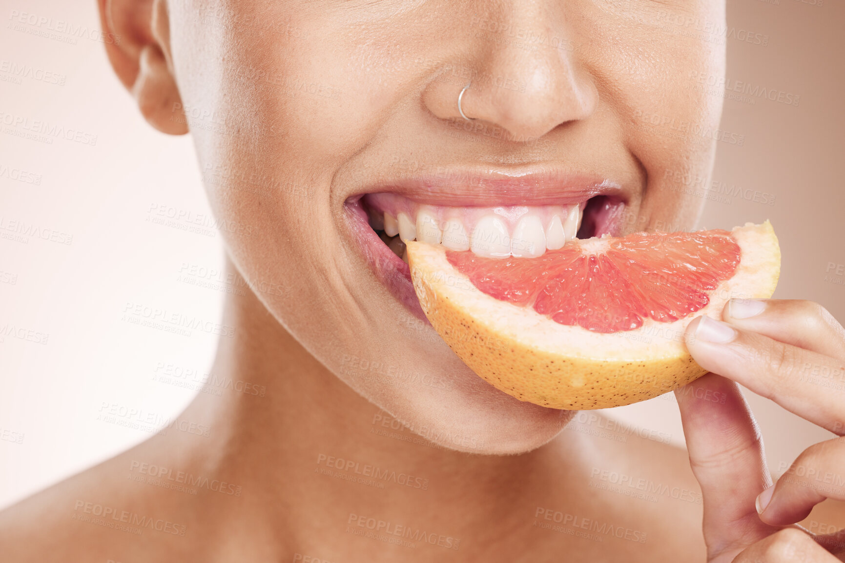 Buy stock photo Diet, nutrition and woman eating grapefruit for skincare, beauty glow and vegan detox on a studio background. Vitamin c, health and mouth of a model advertising a fruit for care of body and skin