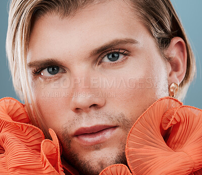 Buy stock photo LGBT, fashion and portrait and gay man with orange clothes, creative beauty or androgynous style. Transgender, queer or bisexual model with makeup, skincare glow and face cosmetics on blue background