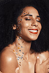 Woman, face or body jewel rhinestones on black background studio for fashion sparkle, festival accessory or creative party crystals. Happy smile, afro beauty model and skin gems with makeup cosmetics