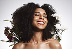 Black woman, beauty and flowers on studio background for healthy skincare. Happy face, floral plants and model with spring fashion, natural makeup and eco wellness for cosmetics, aesthetics and smile