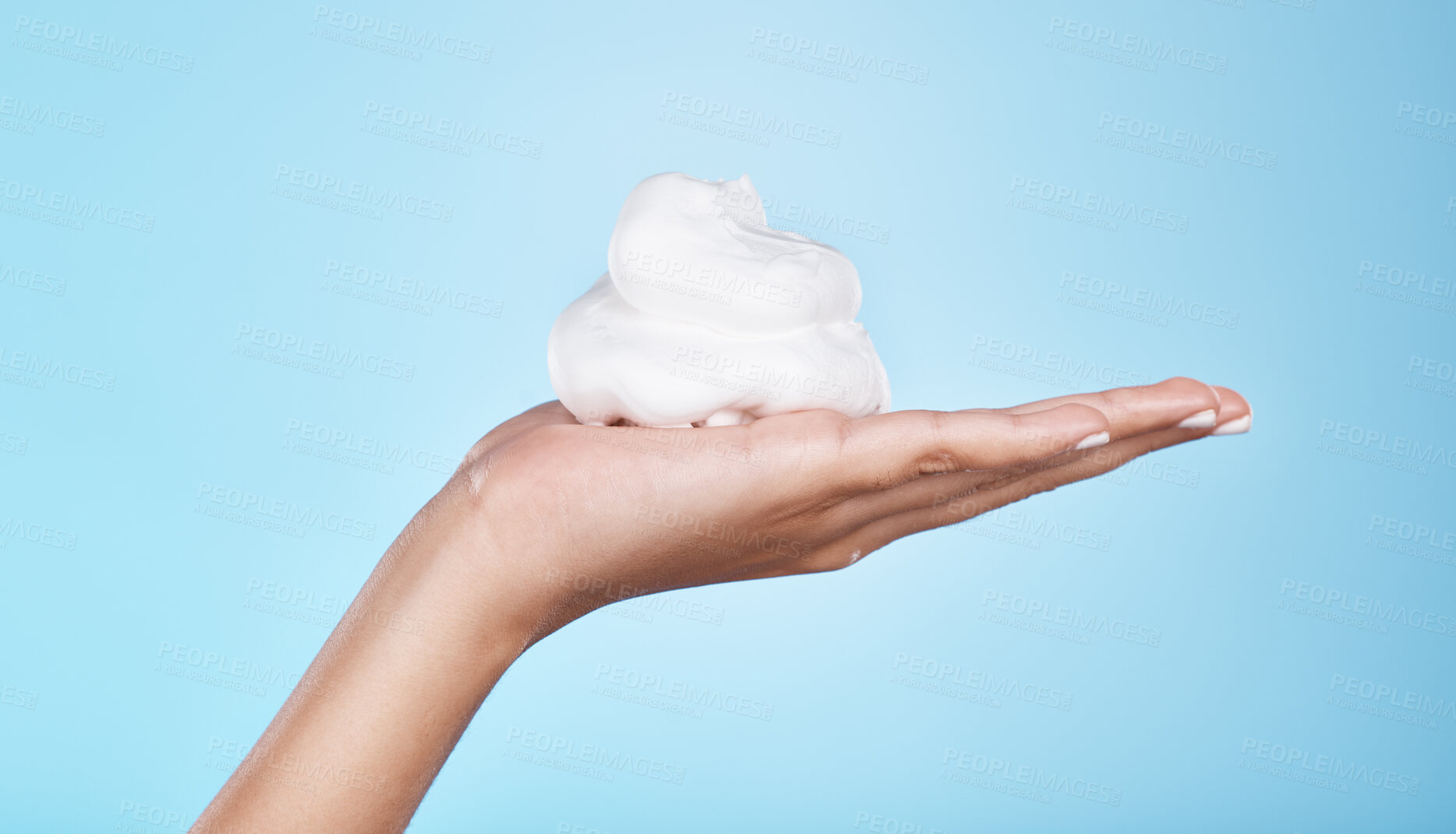 Buy stock photo Skincare, wellness and hands with foam on blue background for treatment, grooming and body care. Cosmetics, spa aesthetic and palm with shaving cream, soap and cleaning products isolated in studio