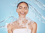 Happy woman, face or water splash skincare on blue background studio in healthcare wellness, Brazil hygiene cleaning or relax grooming. Beauty model, wet or water drops shower for facial dermatology