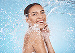 Happy woman, face or water splash skincare on blue background studio for dermatology healthcare wellness, hygiene maintenance or grooming. Portrait, smile or beauty model with water drops in cleaning