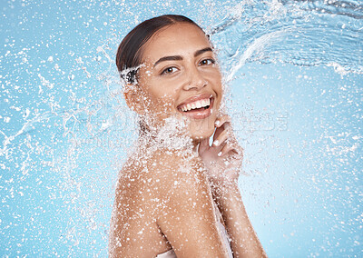 Buy stock photo Happy woman, face or water splash skincare on blue background studio for dermatology healthcare wellness, hygiene maintenance or grooming. Portrait, smile or beauty model with water drops in cleaning