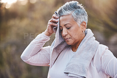 Buy stock photo Fitness, towel and tired senior woman outdoor sweating in nature after running for cardio workout, health and wellness. Elderly female wiping sweat in a forest after a run for healthy lifestyle