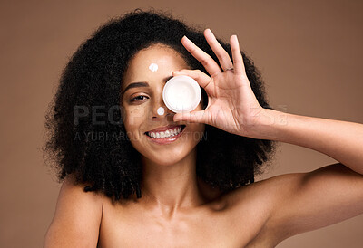 Buy stock photo Face, product and skincare with a model black woman in studio on a brown background for skin treatment. Portrait, container and beauty with an attractive young female posing to promote antiaging care