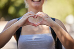 Hands, woman and heart emoji in nature while outdoor for love, freedom and support for summer travel adventure. Happy young female with hand sign and backpack for motivation, peace and wellness