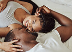 Couple, face and smile in bedroom, morning and love on bed with bonding, care and romance in home. Black couple, eye contact and touch with happiness, holiday or vacation in hotel, room or apartment