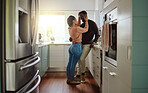 Black couple, love and bonding while together at home with care and happiness in a marriage with commitment. Young man and woman with a romantic hug while in the kitchen in their house or apartment