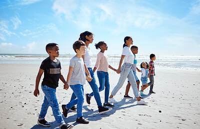 Buy stock photo Summer, children and friends walking on the beach, holding hands together for holiday or vacation. Nature, diversity and walk with a kids group bonding  by the sea or ocean in the day for community