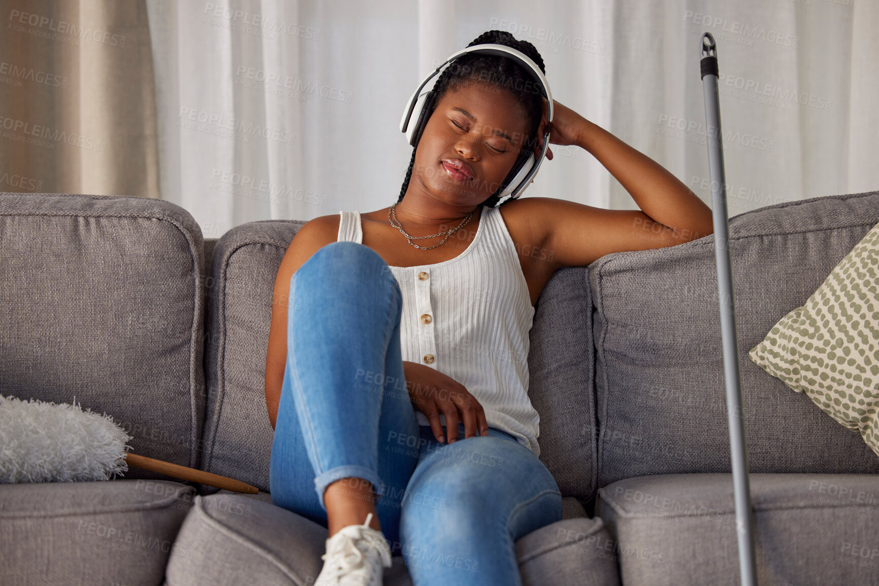 Buy stock photo Black woman, sleeping and listening to music on sofa in the living room after housekeeping, cleaning or dusting at home. African American female domestic relaxing or resting with headphones on couch