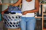 Laundry, woman and holding basket with clean clothes for home housekeeping. Closeup female, clothing fabric and laundry room of spring cleaning service, textile container and maintenance in apartment
