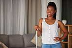 Black woman, broom and cleaning with a smile and mockup in a home living room. Clean house, happy person and relax cleaner proud of housekeeping work feeling calm with happiness by a lounge sofa