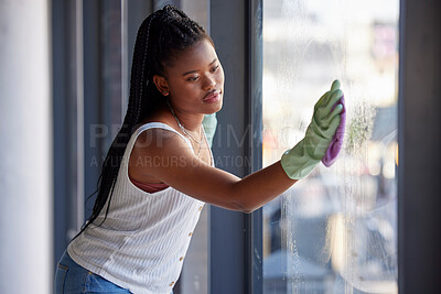 Buy stock photo Housework, hygiene and black woman cleaning the window with cloth while doing housekeeping. Cleaning service, routine and African female cleaner, maid or housewife washing glass door for dust or dirt