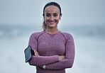 Portrait, runner and woman with arm band, music earphones and motivation for cardio fitness in Sweden. Happy young athlete, arms crossed and training for healthy lifestyle, energy and sports wellness