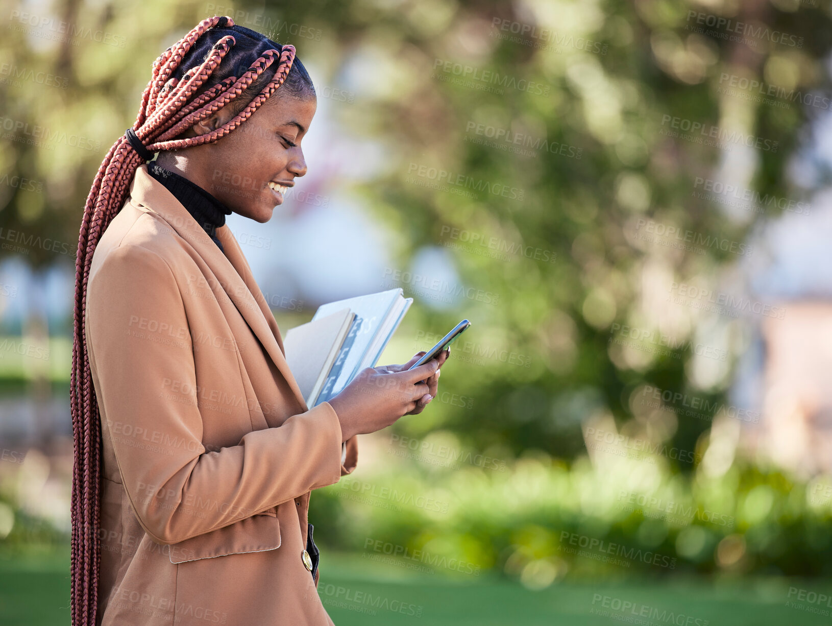 Buy stock photo Phone, scholarship student and black woman at park on social media, researching or texting. Technology, education and happy female with books on 5g mobile smartphone for learning schedule outdoors